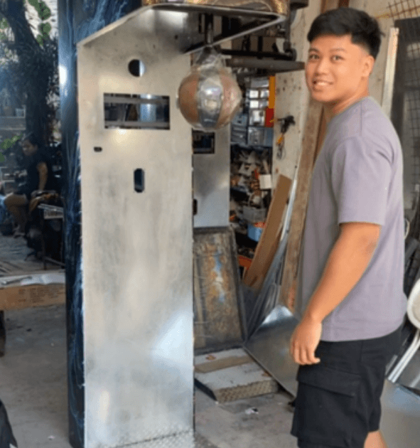 A bare steel machine cabinet standing in the fabrication shop